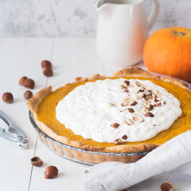 A beautifully sliced pumpkin cheesecake with a golden brown crust and a creamy, spiced pumpkin layer