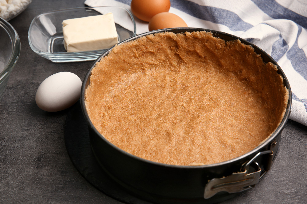 A graham cracker crust in a springform pan
